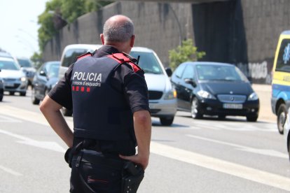 Un agent dels Mossos d'Esquadra supervisa els vehicles que surten de Barcelona per l'avinguda Meridiana.