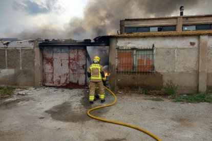 Imatge d'un bomber treballant en l'incendi d'una nau a Reus