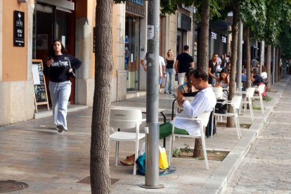 Clients en una terrassa d'un bar de Girona aquest dimarts al matí durant l'hora de l'esmorzar.