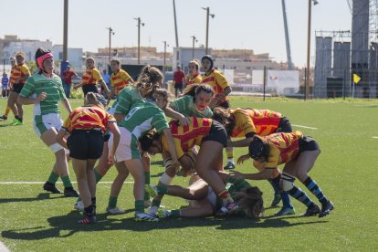 Les jugadores de Catalunya i Euskadi bregant per la pilota ovalada durant el partit disputat ahir al camp de rugbi de l’Anella Mediterrània.