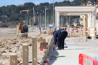 Una persona treballant a les obres de reparació del passeig marítim d'Altafulla.