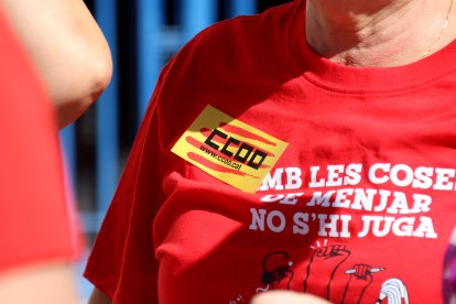 Una de les manifestants per la reducció de la jornada laboral a Tarragona amb una pegatina i samarreta de CCOO.