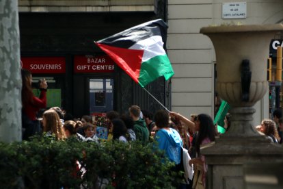 Un manifestant porta una bandera palestina en la mobilització estudiantil de Barcelona.