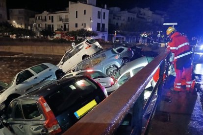 Vehicles arrossegats per la riera a Cadaqués, taponant un pont.