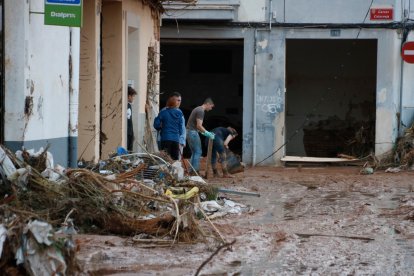 Veïns de Paiporta netegen els baixos d'una casa