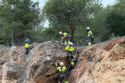 Tècnics de Geotalud treballant en la consolidació i sanejament del talús d'on es va despdrendre una pedra el dia 21 i que ha obligat a tancar l'institut els Alfacs més d'una setmana.