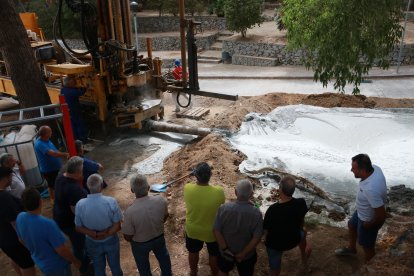 Veïns i curiosos observen la maquinària que perfora el terreny on s'espera fer un pou a Riudecanyes