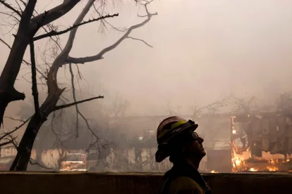 Un bomber del comtat de Los Ángeles observa un incendi a Altadena, Califòrnia.