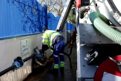 Un operari càrrega aigua no potable per a neteja.