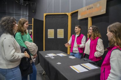 Fotografia de joves informant-se a l’estand de ciències de la salut de la jornada 'De Tu a Tu'.