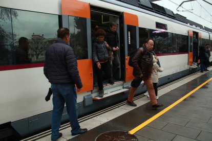 Usuarios bajando y cogiendo un tren de la R2 Sur llegando a la estación de Calafell.