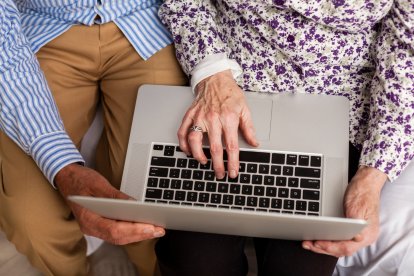 Personas de edad avanzada manipulan un ordenador portátil.