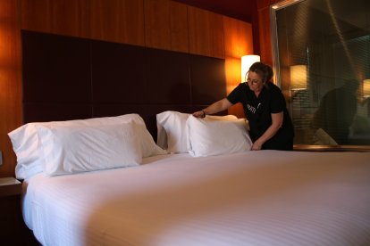 Camarera de pisos preparando la cama de una habitación del Hotel Num.