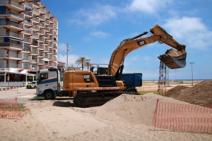 Una de les màquines omplint un dels camions per traspassar sorra del port de Coma-ruga cap a la platja de Calafell.