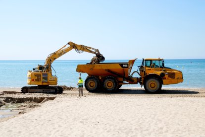 Maquinaria trabajando en el refuerzo de arena en la playa de Altafulla.