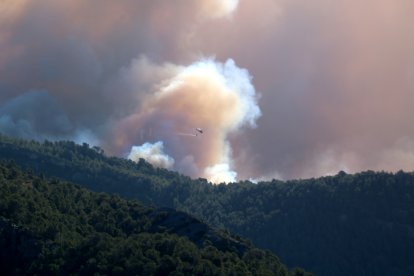 Un helicòpter tira aigua a la Vall de Vinyes de Paüls cap on s'ha desplaçat l'incendi més actiu.