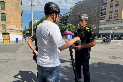 Dos agents de la GUT aturant un usuari de VMP.