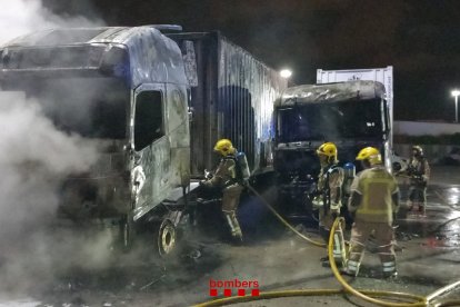 Els bombers duent a terme les tasques d'extinció dels dos camions.