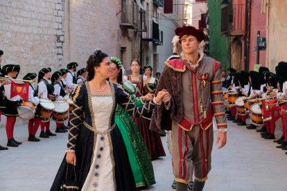 Una parella participant a l'entrega d'estandards de les famílies nobles de la Festa del Renaixament es miren mentre es dirigeixen als Reials Col·legis de Tortosa.