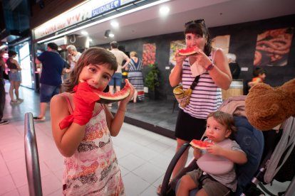 Imagen de una familia disfrutando de sus trozos de sandía en el Mercado Central de Tarragona.