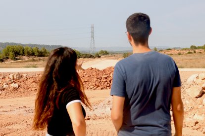 Dos dels membres de la plataforma En peu de terra als terrenys on s'està construint el Logis Montblanc