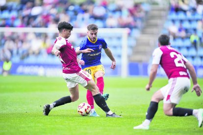 El lateral Martí Vilà pressionat per Óscar Sanz en el duel del Nàstic el curs passat a l’Estadi Nacional.