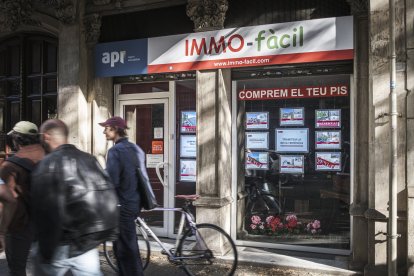 Façana d’una immobiliària on anuncien que compren pisos.