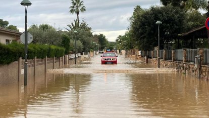 Un vehicle de Bombers avança per un carrer totalment inundat a la Móra.