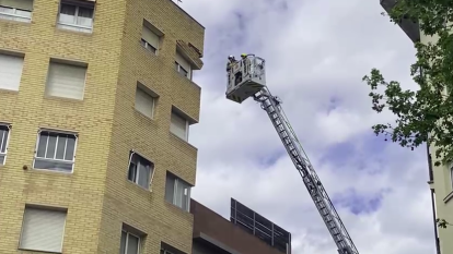 Bombers treballant a la façana afectada al carrer Jaume I de Reus.