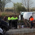 Primer pla d'un grup d'agents dels Mossos d'Esquadra al costat de l'autocar sinistrat a l'AP-7, el 20 de març del 2016