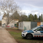 La casa custodiada amb un vehicle policial.