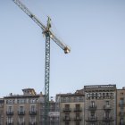 Una grua treballa en la construcció d'un edifici d'habitatges.