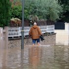 Un home caminant per un carrer inundat de la urbanització La Móra de Tarragona.