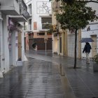 Dos personas caminan bajo la lluvia por Cambrils.