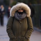 Una mujer pasea por Madrid en una fría mañana.