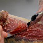 Imagen de una persona cortando jamón ibérico.