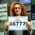 La responsable de l’administració d'Alcanar, Mònica Alvaredo, subjectant el cartell del tercer premi de la rifa de Reis després de vendre un dècim.