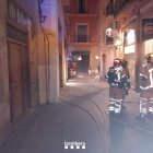 Els bombers treballant en l'incendi al local del carrer de la Nau.