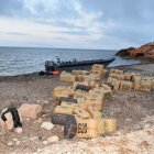 Imatge de la llanxa de transport i els fardells d'haixix trobats a la platja de port Olivet, a l'Ametlla de Mar
