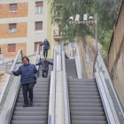 Usuaris de les escales mecàniques del carrer Vapor, baixant els graons a peu.