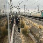 Passatgers baixant d'un tren i caminant per les vies degut a una incidència al seu tren.