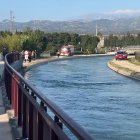 Efectius dels Bombers i dels Mossos d'Esquadra treballant en les tasques de salvament al punt on han caigut el cotxe al canal de Roquetes.