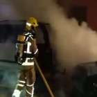 Els bombers treballant en l'extinció del l'incendi dels dos vehicles.