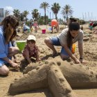 Una família participant en el taller d’estructures de sorra a la platja de Ponent de Salou