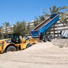 Un dels camions procedents del port de Coma-ruga abocant sorra a la platja de Calafell.