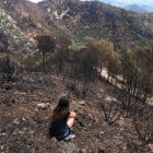 _La Maria, veïna de Paüls, observa la seva finca on viu amb gairebé la meitat del terreny cremat per l'incendi