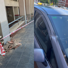 A l'esquerra, la façana caiguda, a la dreta, un dels cotxes afectats