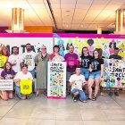 La consellera Sandra Ramos i l’artista Bet Díez (al centre) acompanyades per representants de les diferents entitats que produeixen les peces de marxandatge.