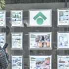 Una dona mira els anuncis d’habitatges exposats en una immobiliària.