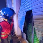 Els bombers van haver de tallar la persiana per poder accedir al local.